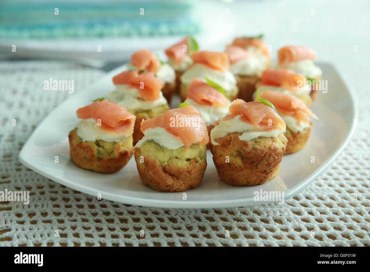 Gli spinaci fatti in casa mini muffin con crema di formaggio e salmone affumicato su bianco piatto Foto Stock