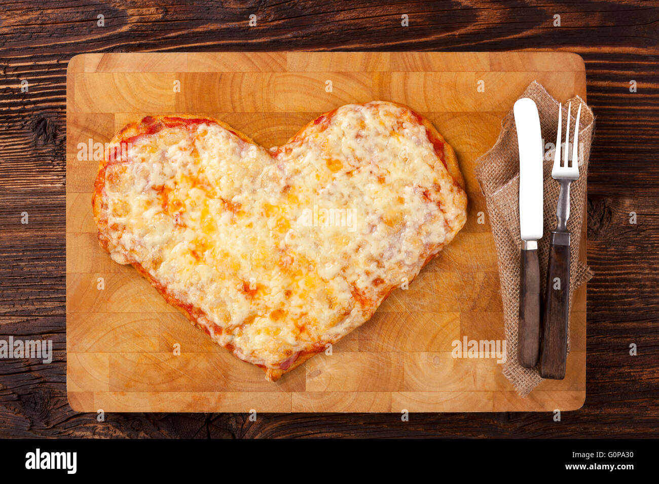 Culinario mangiare pizza. Pizza a forma di cuore sul tavolo di legno, vista dall'alto. Culinario mangiare pizza. Mi piace la pizza. Foto Stock