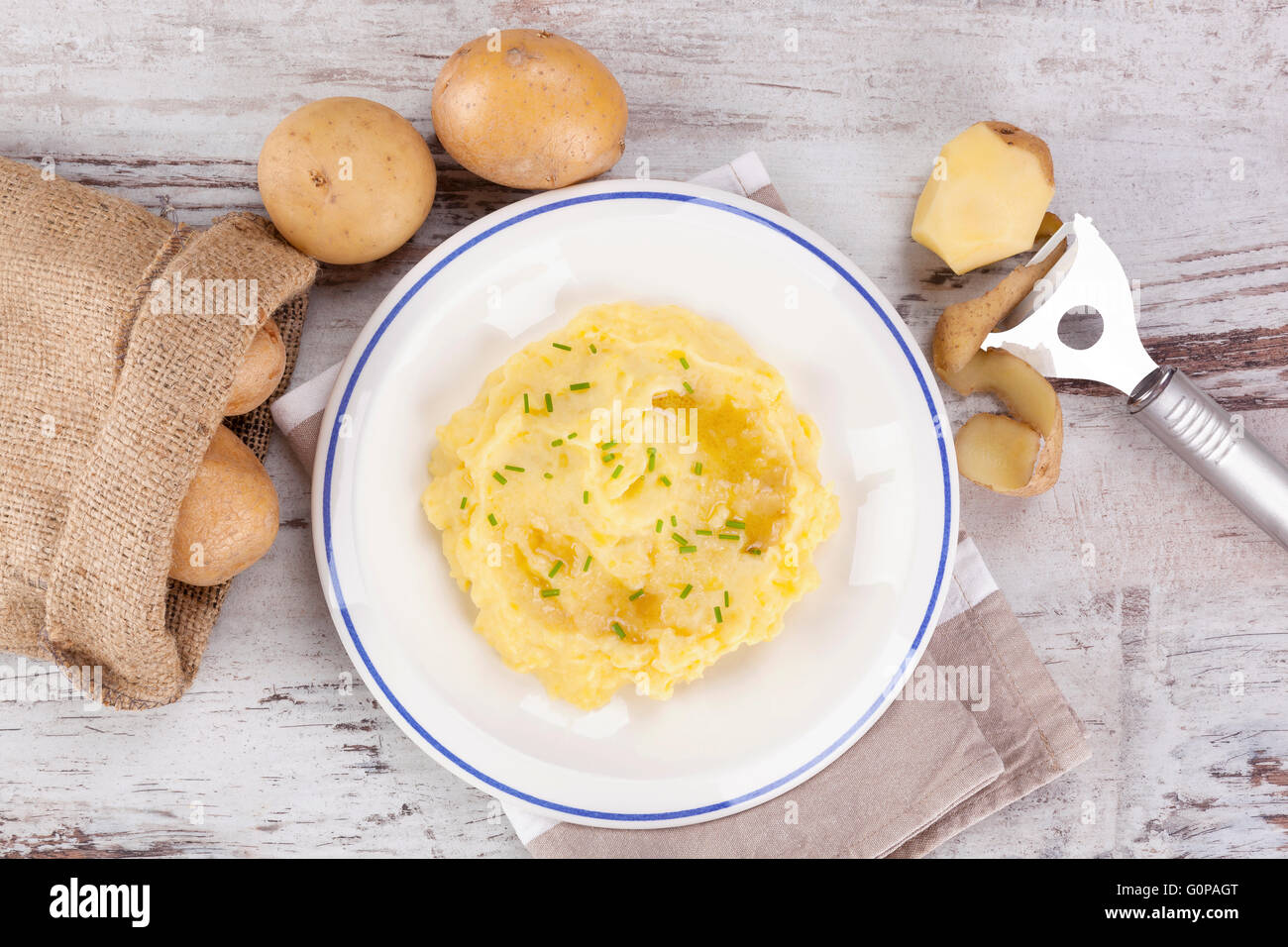 Purè di patate su piastra, mature le patate in una sacca di tela in background. Potatoe culinaria mangiare. Foto Stock