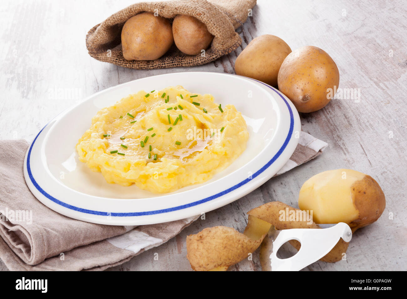 Purè di patate su piastra, mature le patate in una sacca di tela in background. Potatoe culinaria mangiare. Foto Stock