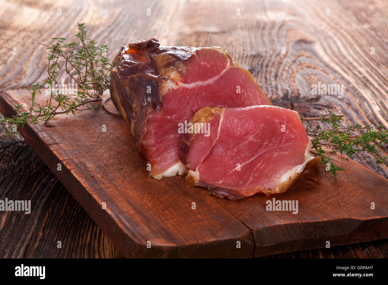 Tradizionale carne affumicata su un tavolo di legno. Culinario mangiare carne. Foto Stock