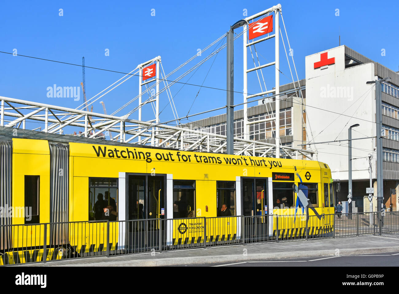 Logo National Rail British Railways sopra East Croydon London England UK stazione ferroviaria e giallo tramlink slogan di sicurezza per i pedoni alla fermata del tram Foto Stock