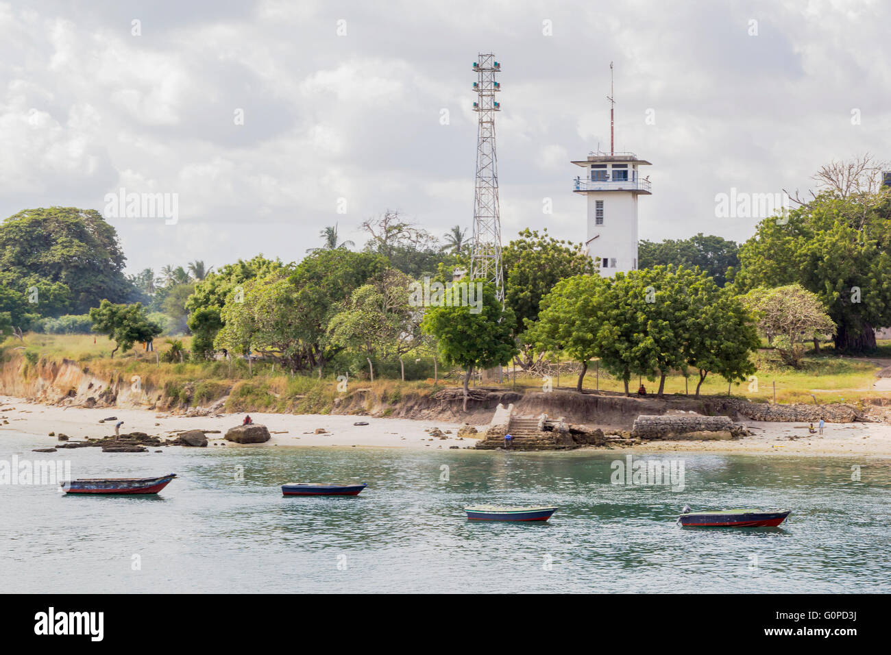 Numerose piccole imbarcazioni ormeggiate nella baia di Stone Town Zanzibar Tanzania, vicino al faro Foto Stock