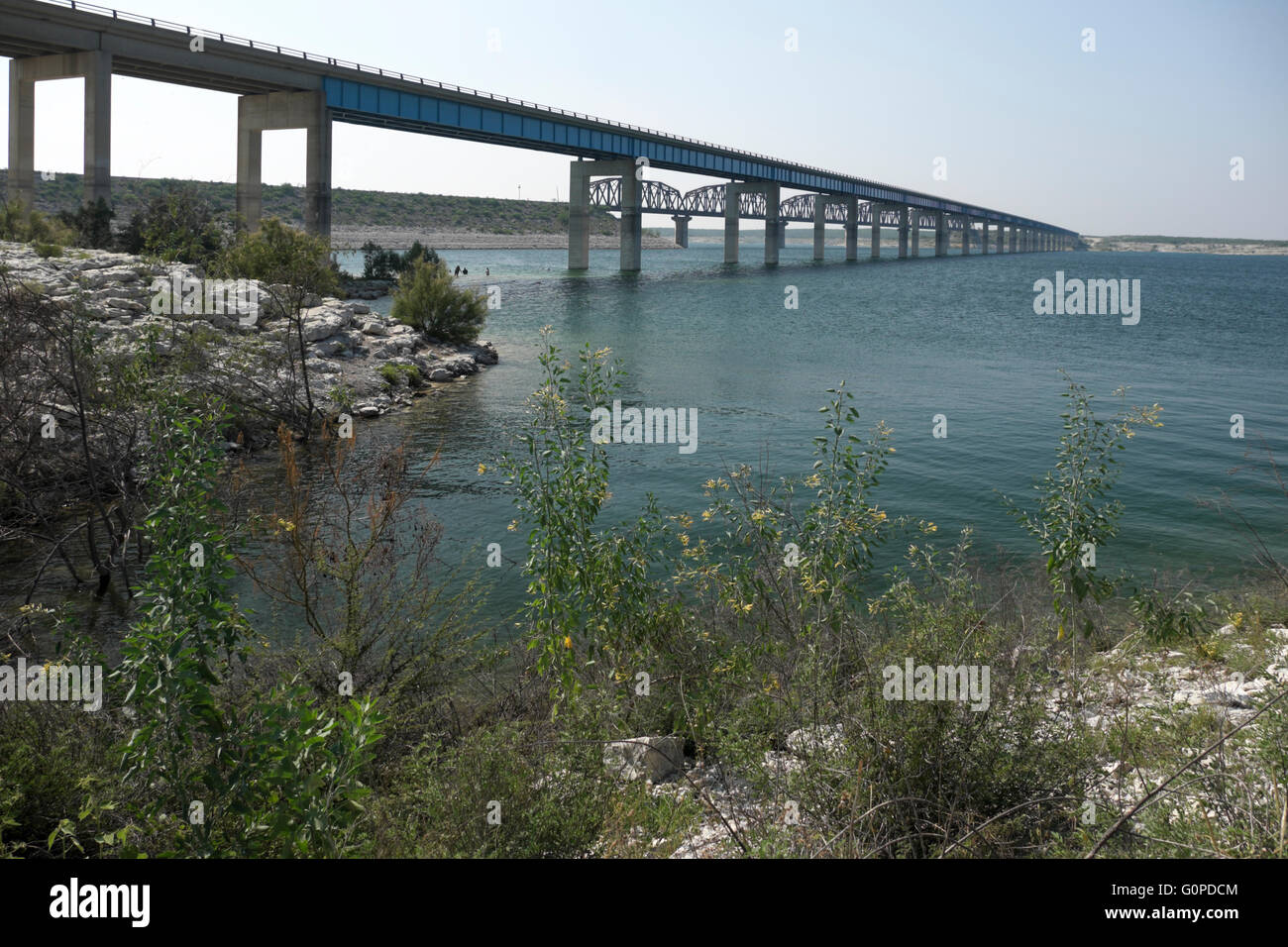 Persone a giocare nelle acque del lago Amistad sotto il ponte del veicolo in corrispondenza del governatore lo sbarco nei pressi del Rio, Texas. Foto Stock