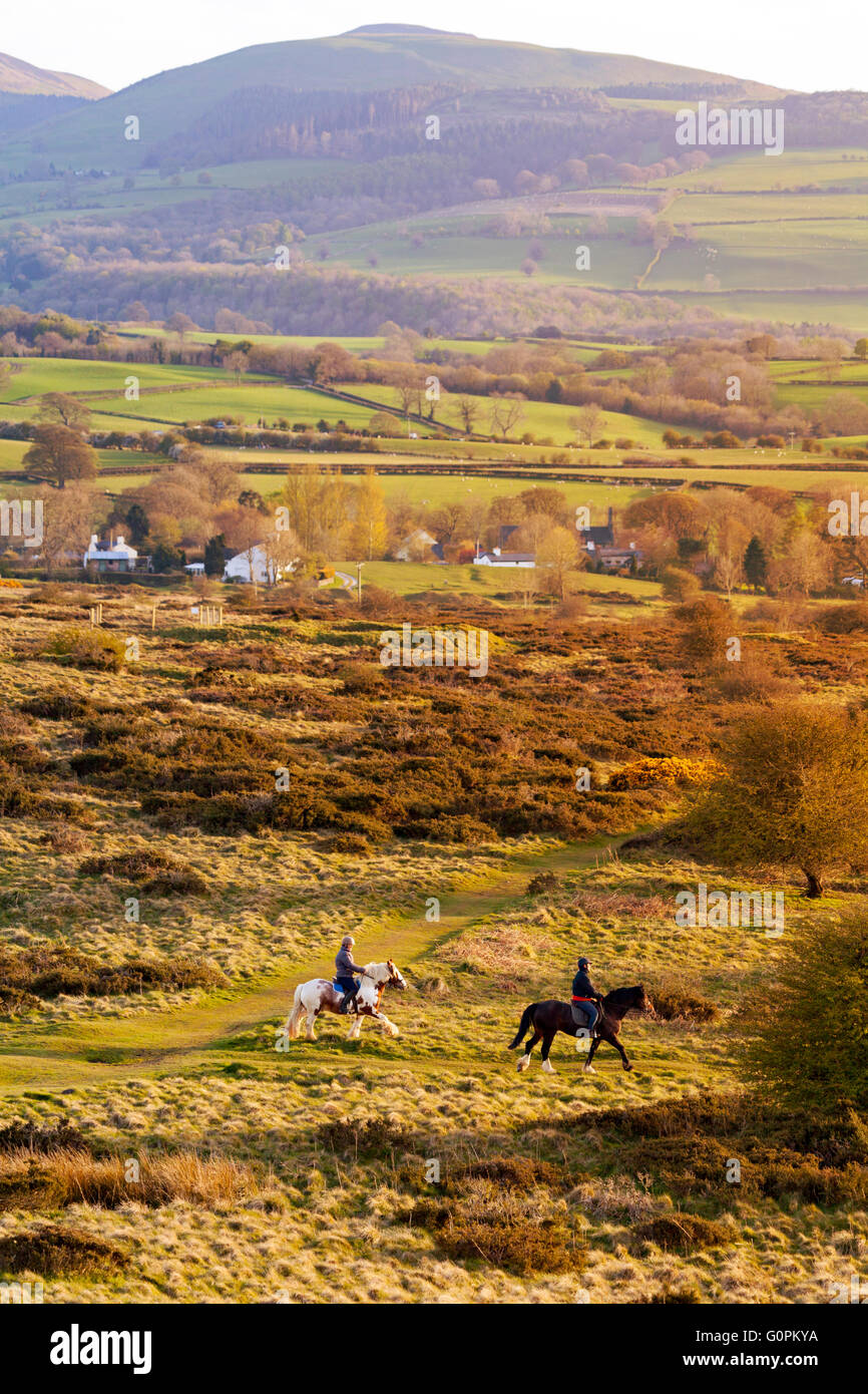 Flintshire, Galles del Nord, Regno Unito meteo- Regno Unito le temperature cominciano a salire questa settimana risultante in +20C gradi da weekend. cavalieri godersi il sole di setting come si imposta su halkyn montagna che domina la gamma clwydian o clwydian hills da flintshire con moel arthur Foto Stock