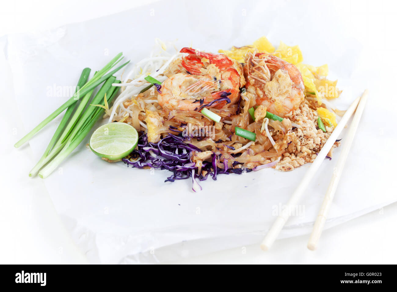 Spaghettini fritti in stile Thai con gamberi. Friggere gli spaghetti con i gamberi in (Pad Thai) cucina tailandese sul colore bianco involucro alimentare. Foto Stock