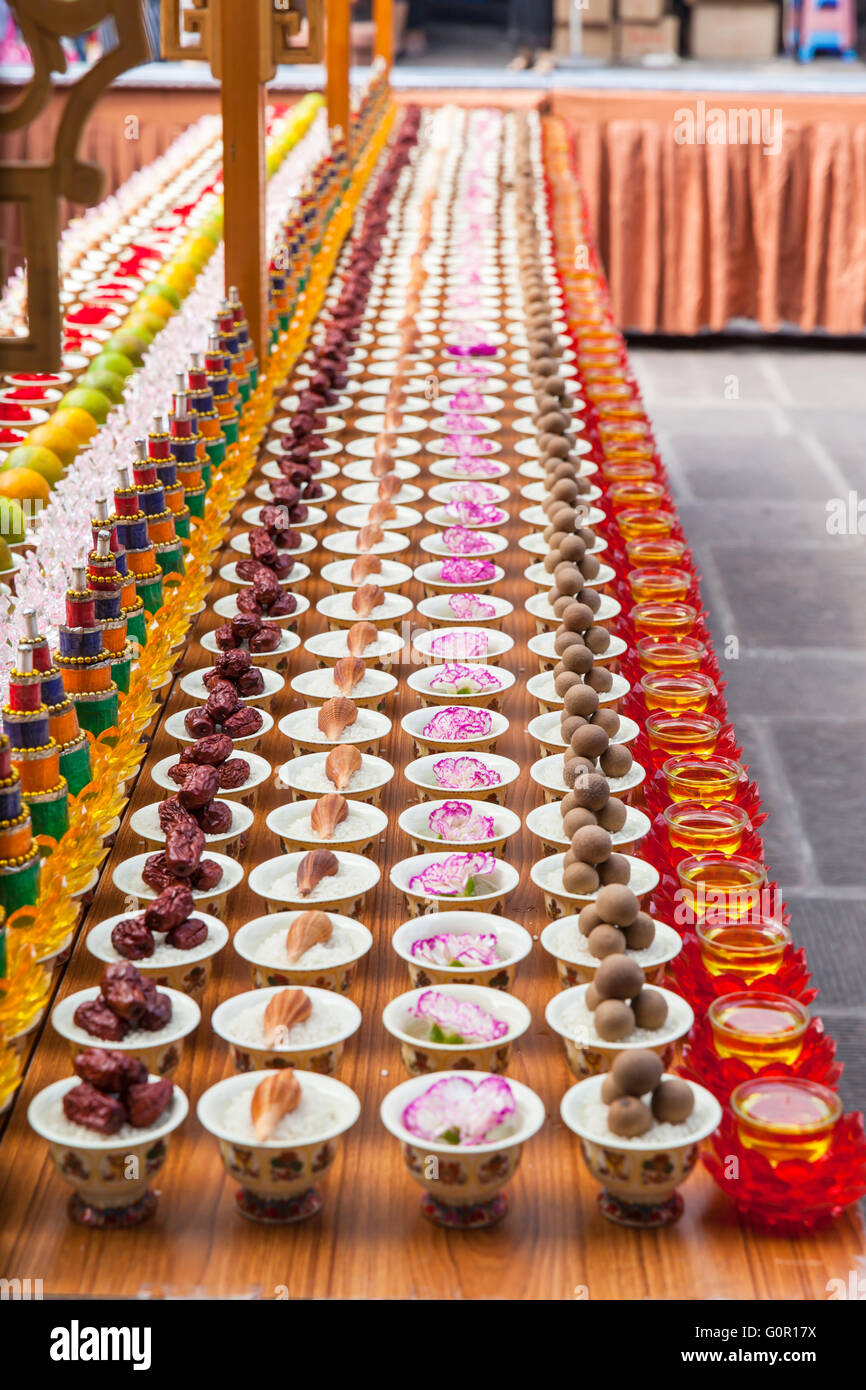 Vista ravvicinata di vari di sacrificio in cinese tempio buddista, il fuoco selettivo Foto Stock