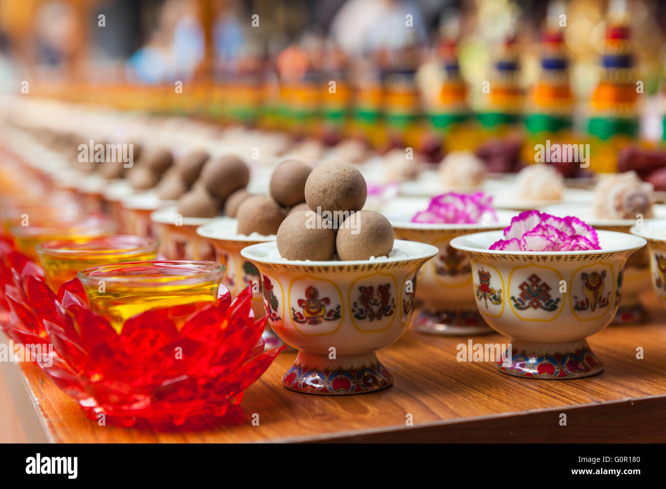 Vista ravvicinata di vari di sacrificio in cinese tempio buddista, il fuoco selettivo Foto Stock