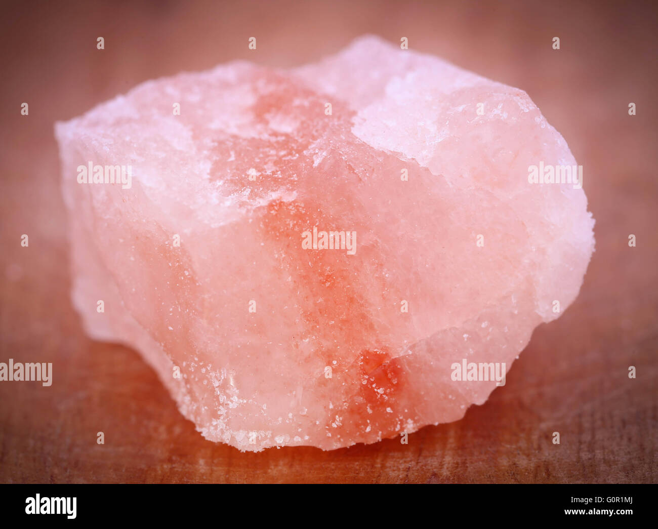 Saindhava lavana o Rosa himalayano sale di roccia su una superficie di legno Foto Stock