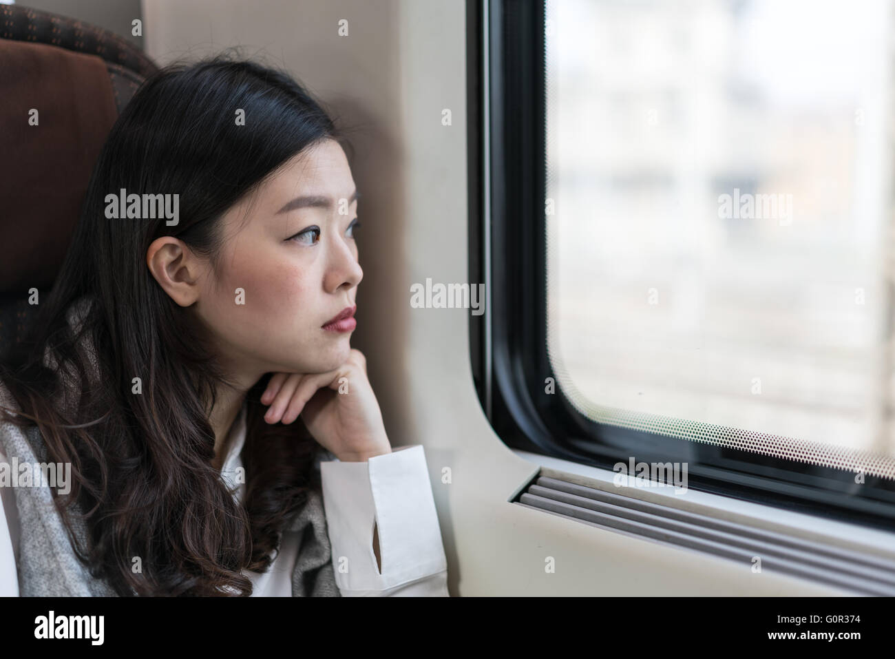 Bella donna asiatica guardando fuori della finestra del treno, con spazio di copia Foto Stock