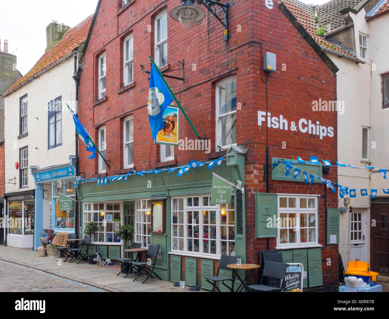 Monk's Haven Café Brasserie in Church street a Whitby che offre pesce e patatine adornato nello Yorkshire Bandiere Foto Stock