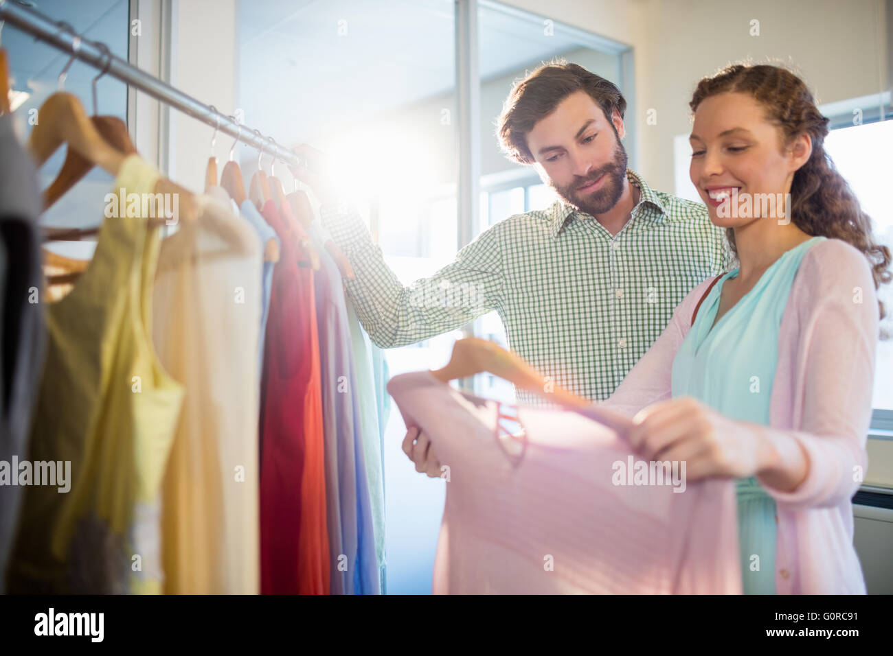 La donna che mostra camicia per l uomo al centro commerciale per lo shopping Foto Stock