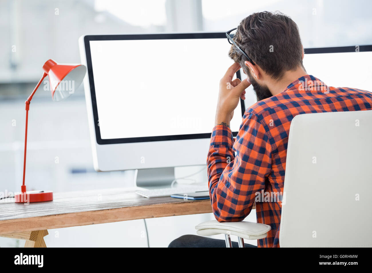 Hipster seduto di fronte a un computer Foto Stock