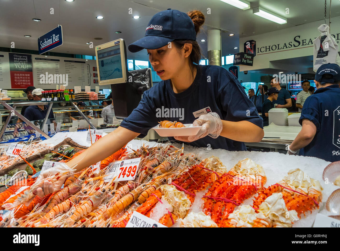 Fornitore preparazione del pesce per un acquirente nel famoso Sydney Fish Market, Sydney, New South Wale, Australia Foto Stock