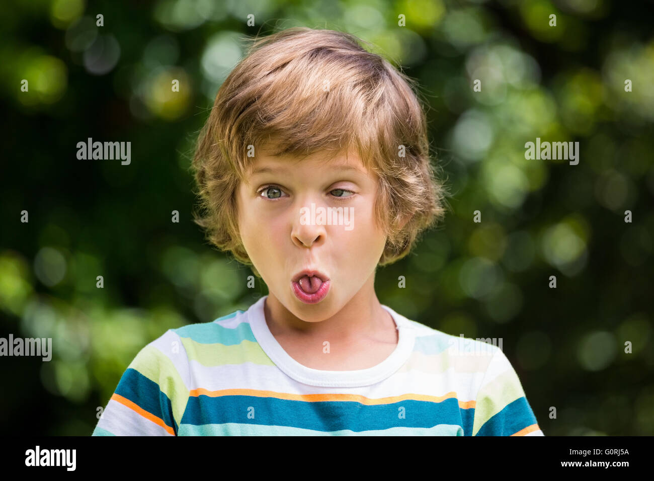 Un ragazzino sta facendo una faccia buffa Foto Stock