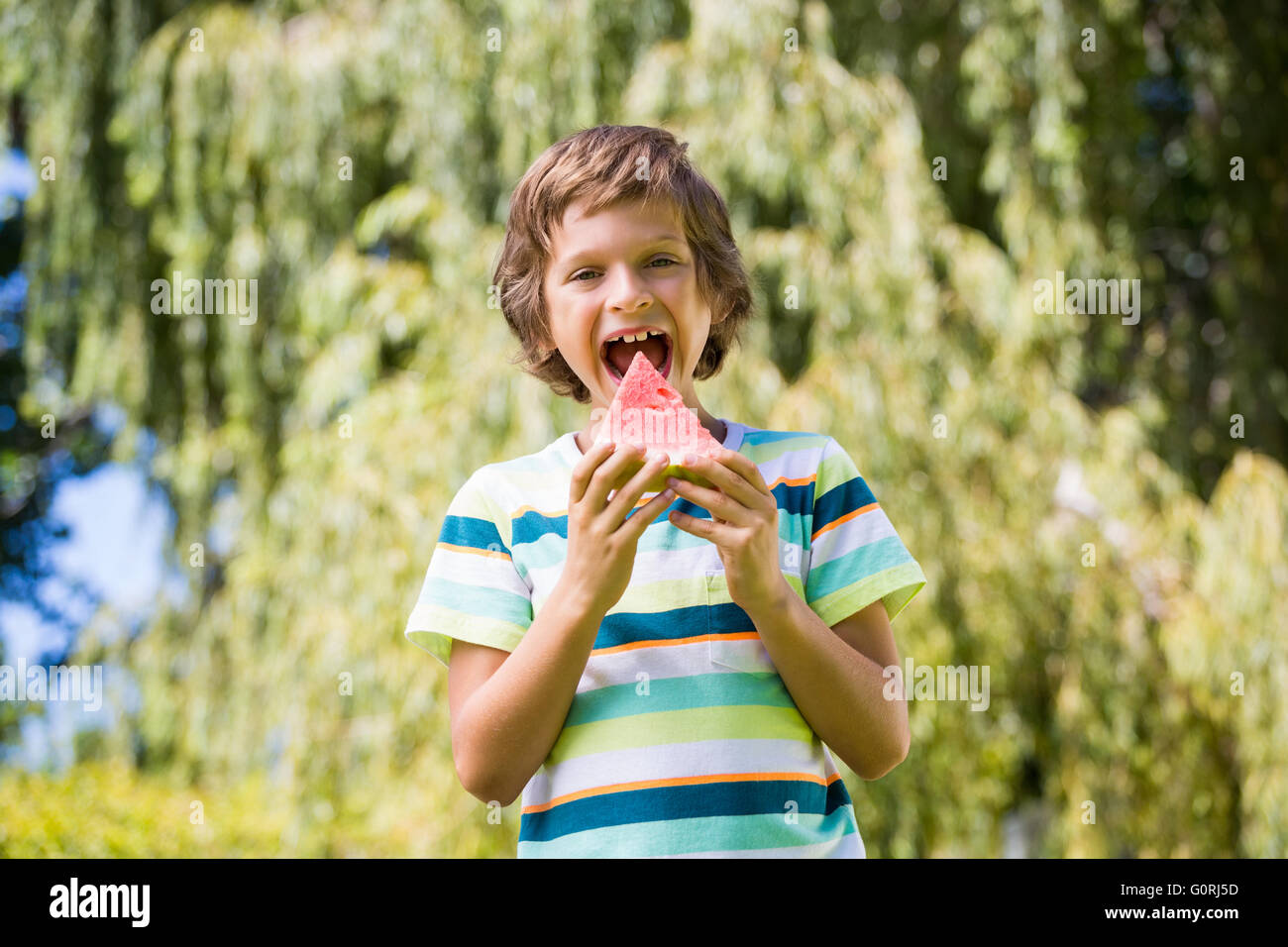 Un ragazzino sta andando a mangiare un cocomero Foto Stock