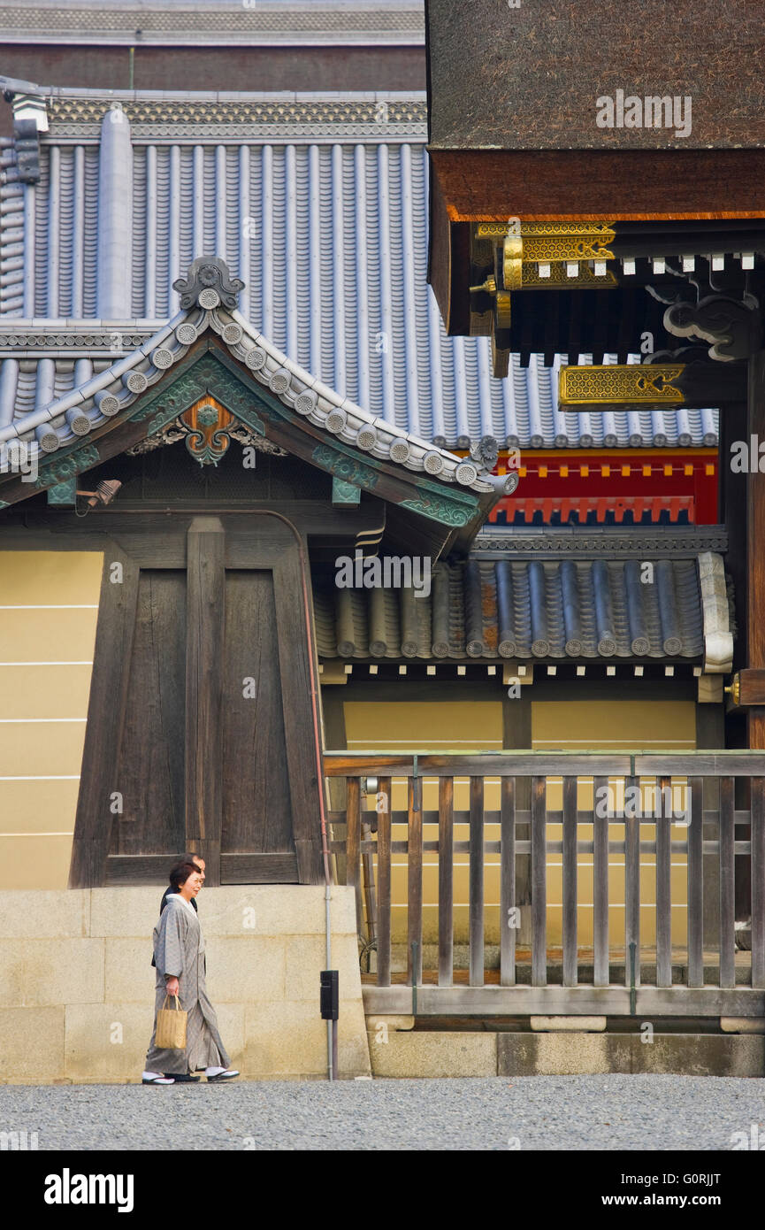 Passaggio di un giovane giapponese di fornire la scala per la grande dimensione della gate Kenreimon presso il Palazzo Imperiale di Kyoto, nel centro di Kyoto, Giappone. Foto Stock