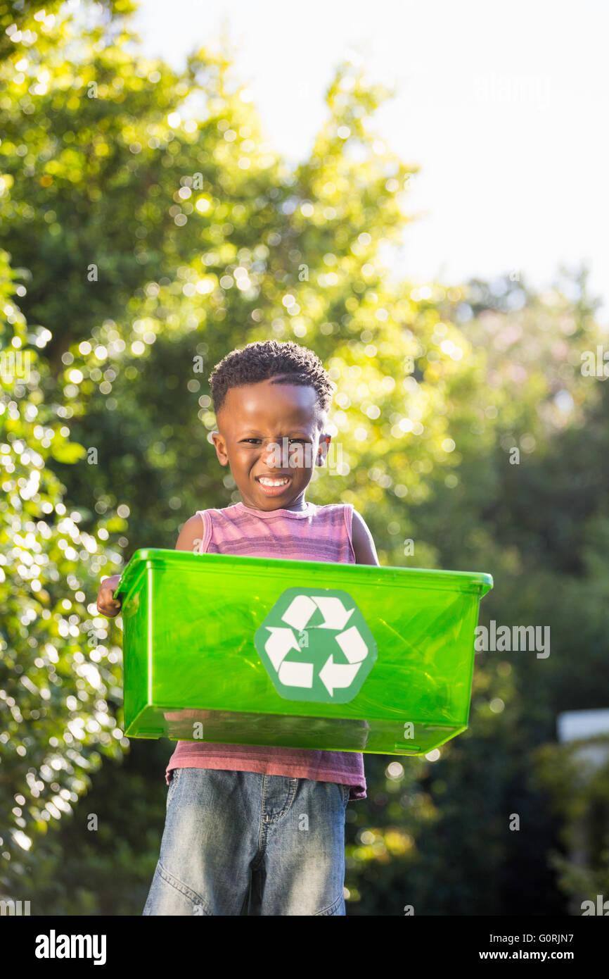 Ragazzo che porta un cestino di riciclo Foto Stock