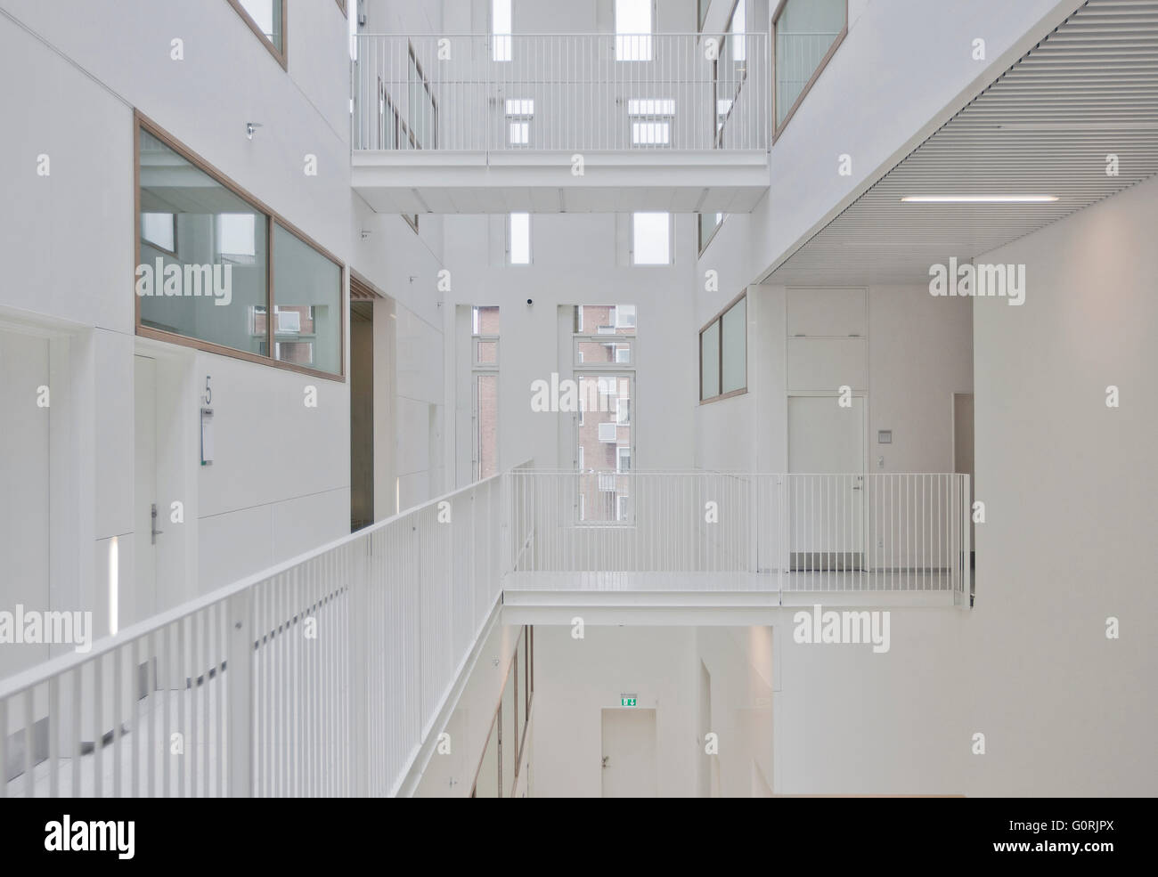 Frederiksberg Courthouse prende il segnale dal tetto distinti e materiali robusti della vicina neo-classico impianto progettato da Hack Kampmann. Vista di un moderno e bianco corridoio e scale Ringhiere. Foto Stock