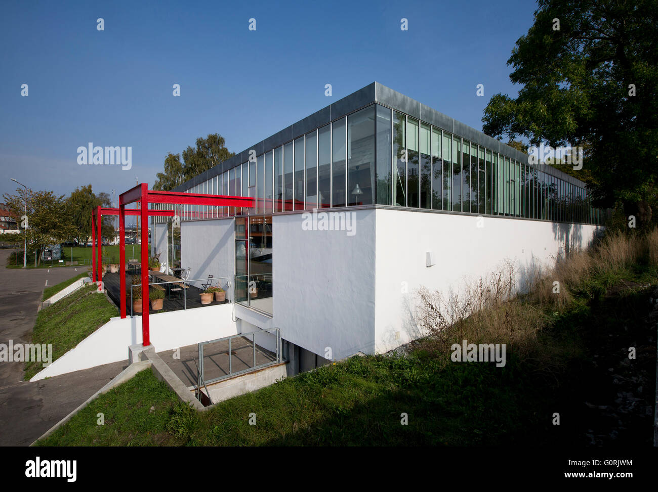 La trasformazione di un ex stazione della macchina per la marina militare danese in ufficio architettonico da e per Vandkunsten. Vista esterna dell'ufficio moderno. Rosso. Finestre da pavimento a soffitto. Foto Stock