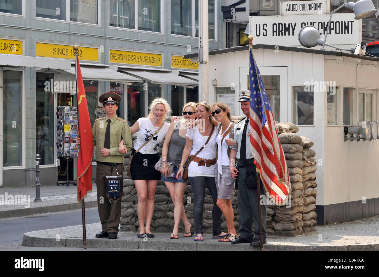 I turisti, attori, soldati, che pongono, foto, souvenir, il Checkpoint Charlie, Friedrichstrasse, nel quartiere Mitte di Berlino, Germania Foto Stock