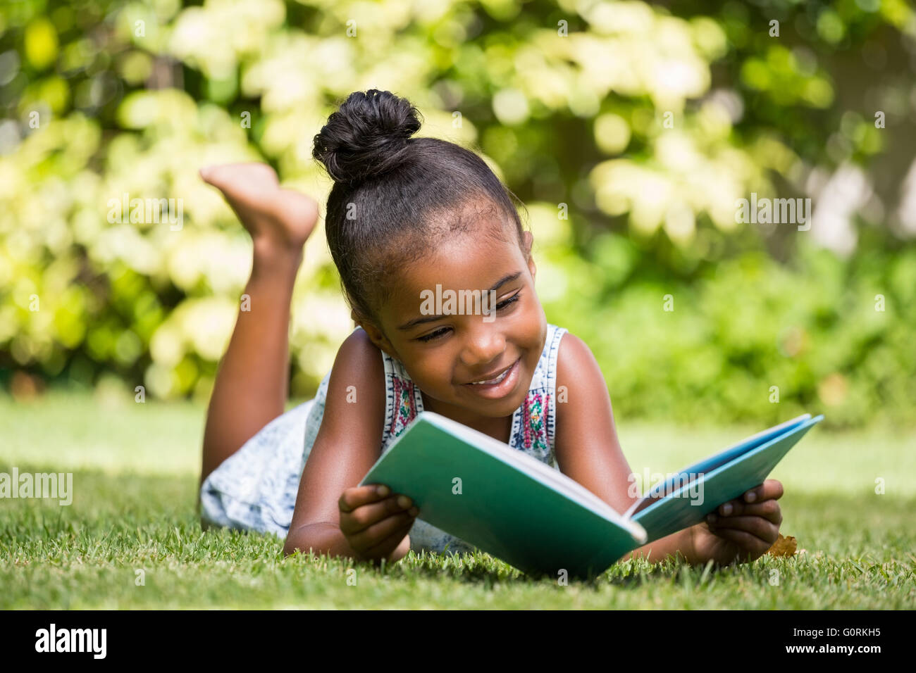 Bambina la lettura di un libro in posizione di parcheggio Foto Stock