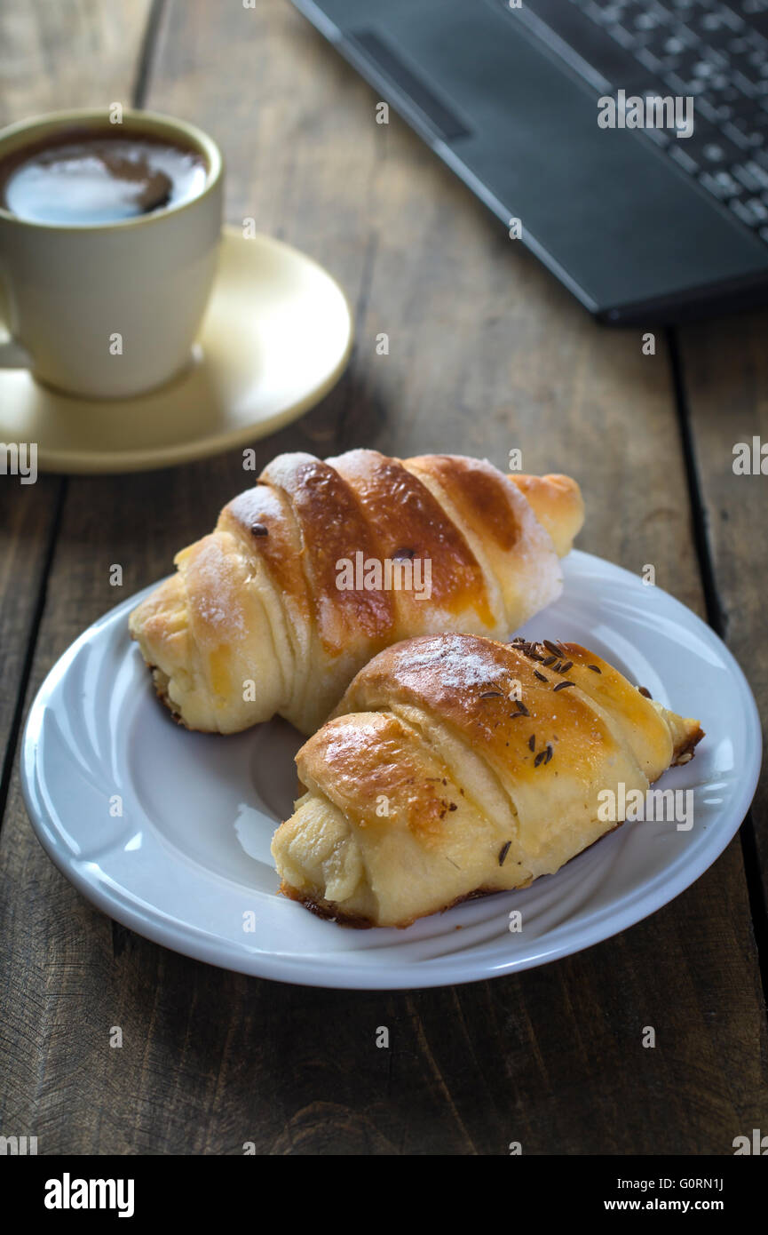 Prima colazione in ufficio a lavorare con il computer portatile Foto Stock
