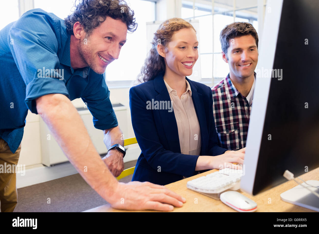 Gli imprenditori sorridente e in cerca di un computer Foto Stock