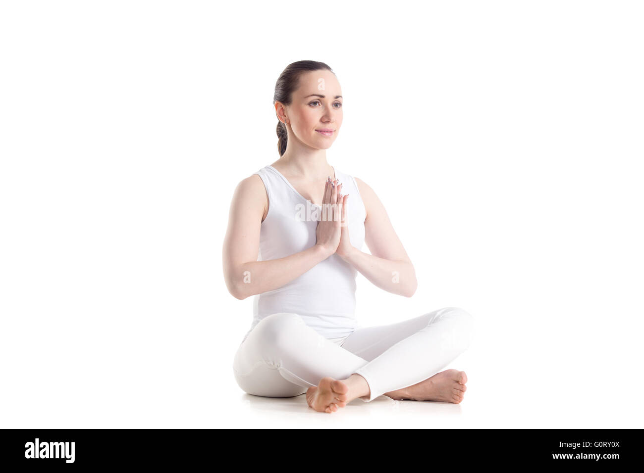 Sporty bella giovane donna seduta in sede di facile posa, Sukhasana con mani in Namaste, asana per la meditazione, pranayama Foto Stock