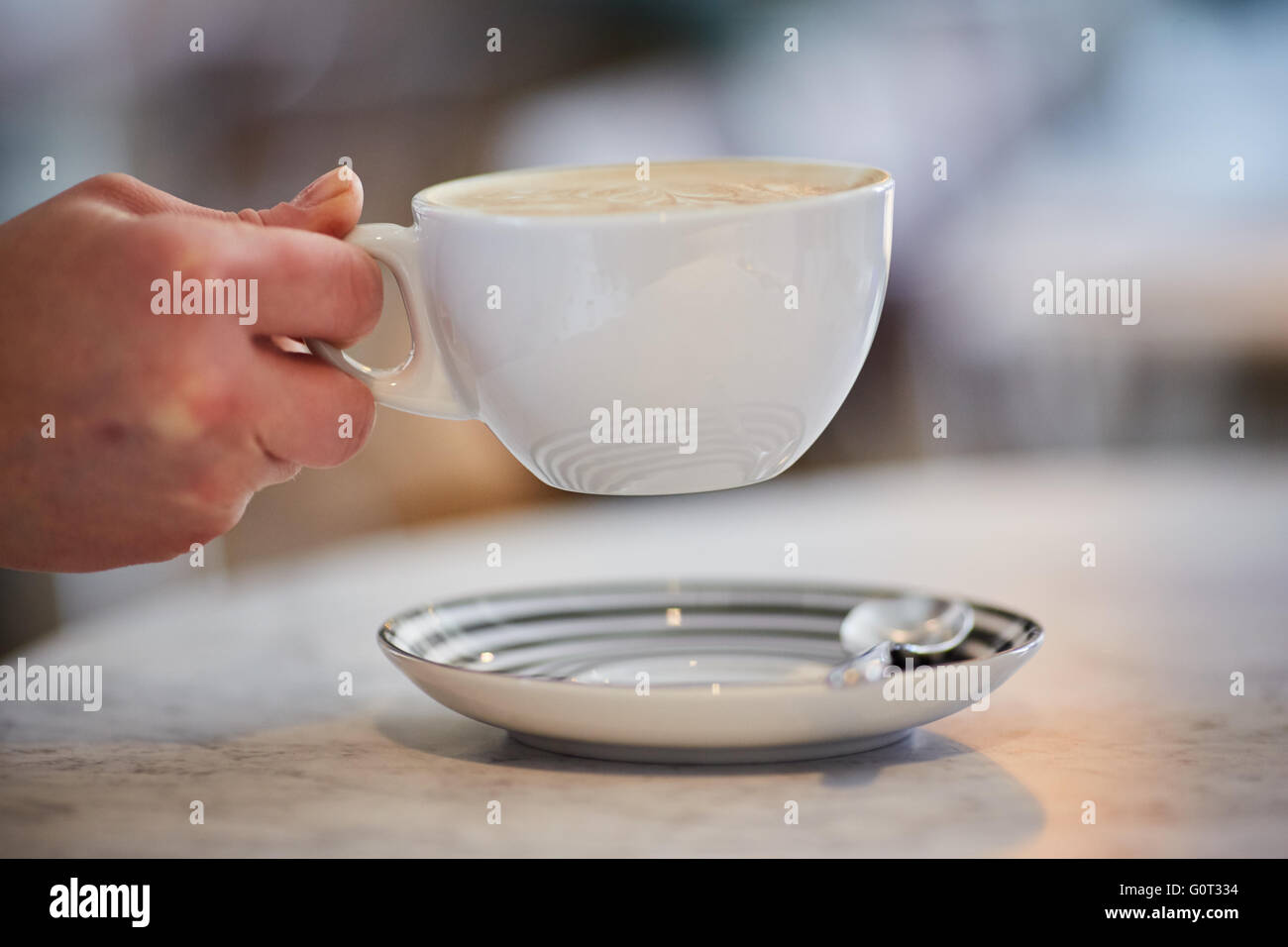 Coffee shop bicchiere mano azienda grande caffè tè bevanda calda cina bianco mug piattino copyspace tempo di pausa Foto Stock