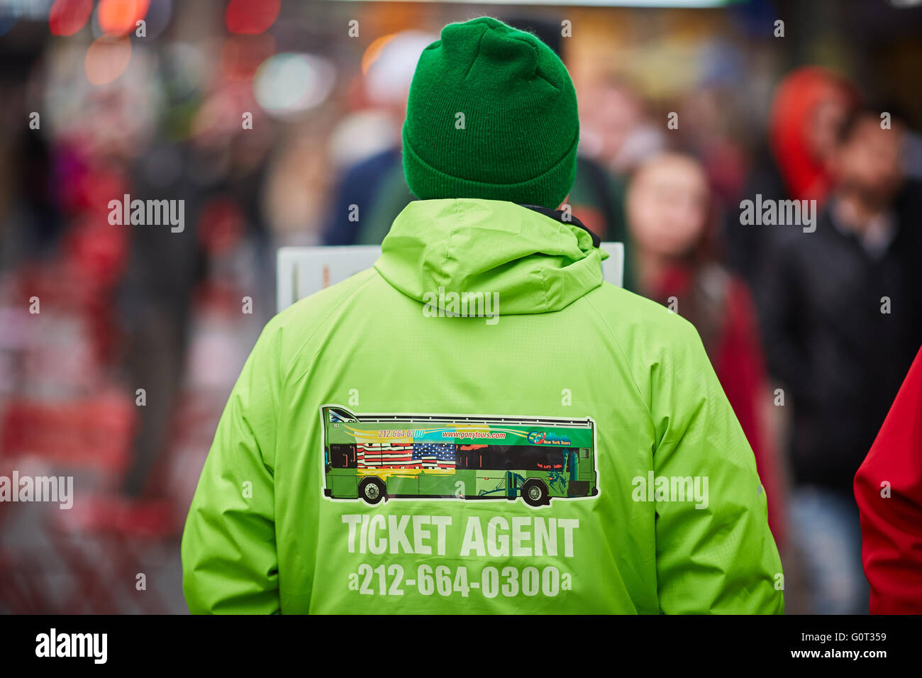 New York Times Square verde di vendita uniforme hop on off biglietti autobus temolo rappresentante Coach tours venditore con segno stoppi Foto Stock