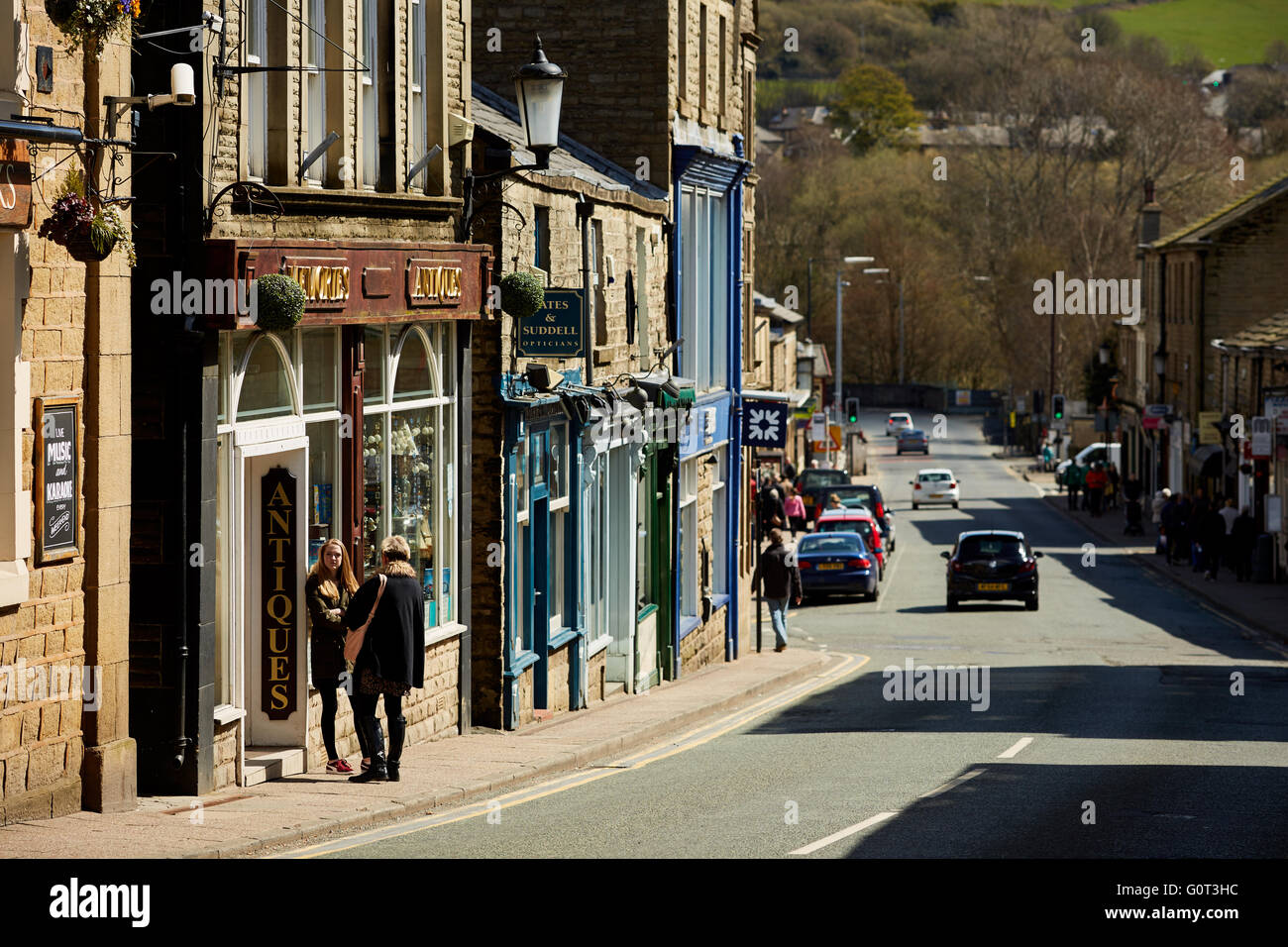 Rams fondo arte pubblica stemma Ramsbottom negozi di paese guardando giù Bridge Street pietra negozi terrazzate colline in backgro Foto Stock