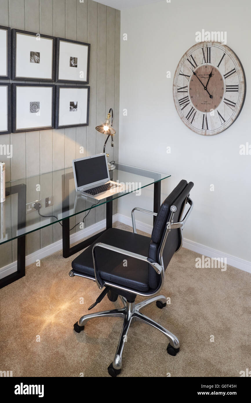Visualizza home studio interno ufficio portatile scrivania in vetro orologio sulla parete crema adulti stampa scura sfondo spazio calmo Suburban su Foto Stock