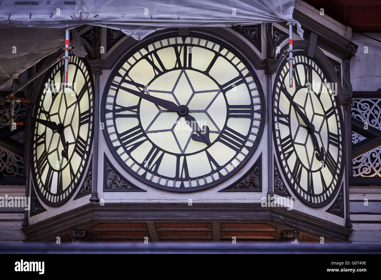 A Londra la stazione ferroviaria di Paddington grande orologio 3 facce numero romano I ponteggi restauro orologio tempo le mani dicendo Foto Stock