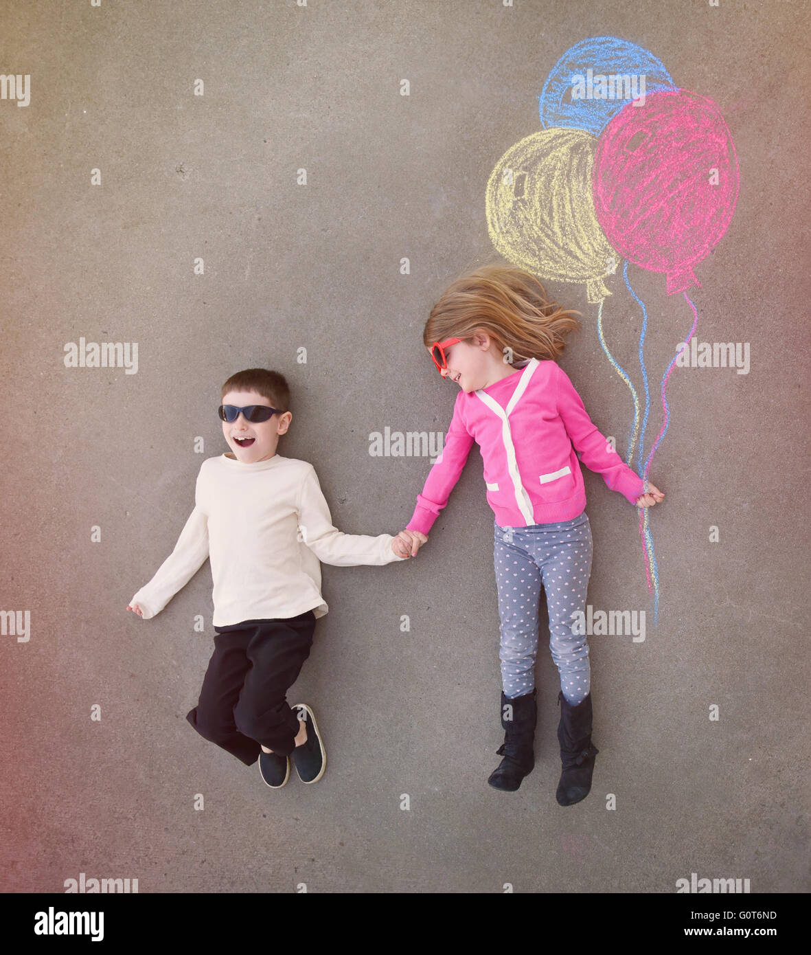 I bambini sono tenendo le mani al di fuori con colorati chalk palloncini delineato sul cemento per un creativo, artigianali o il concetto di riproduzione Foto Stock