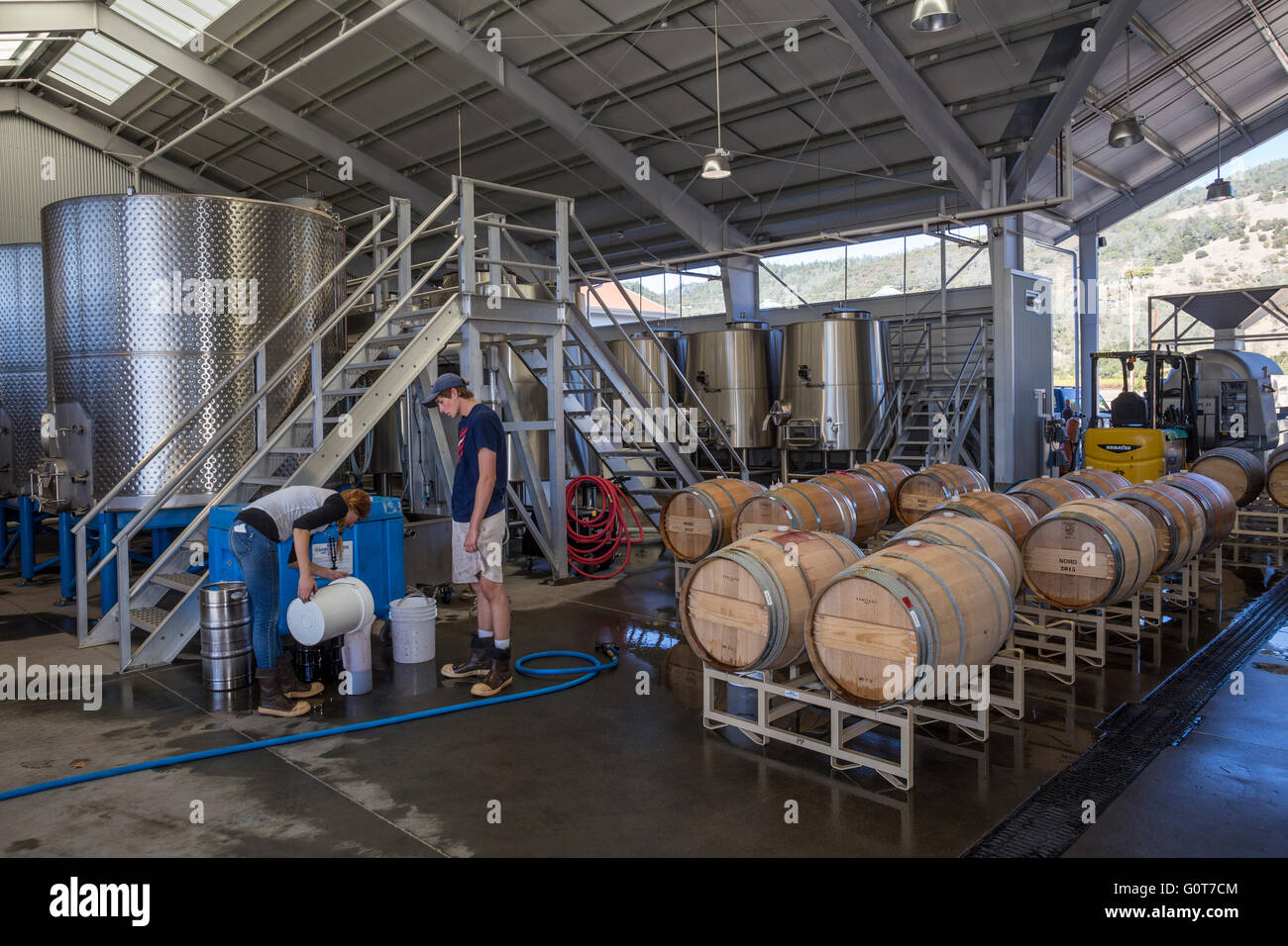 Lavoratori rabbocco di botte di vino nella zona di fermentazione al rammendo cantina di parete lungo silverado trail nella valle di Napa California Foto Stock