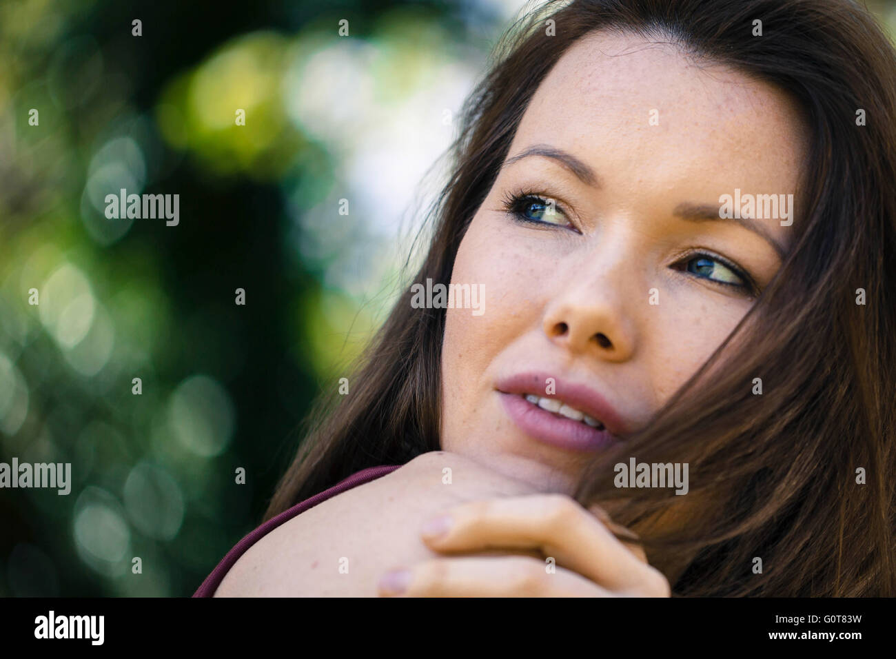 Ritratto di un felice donna rilassata fuori guardando sopra la sua spalla Foto Stock