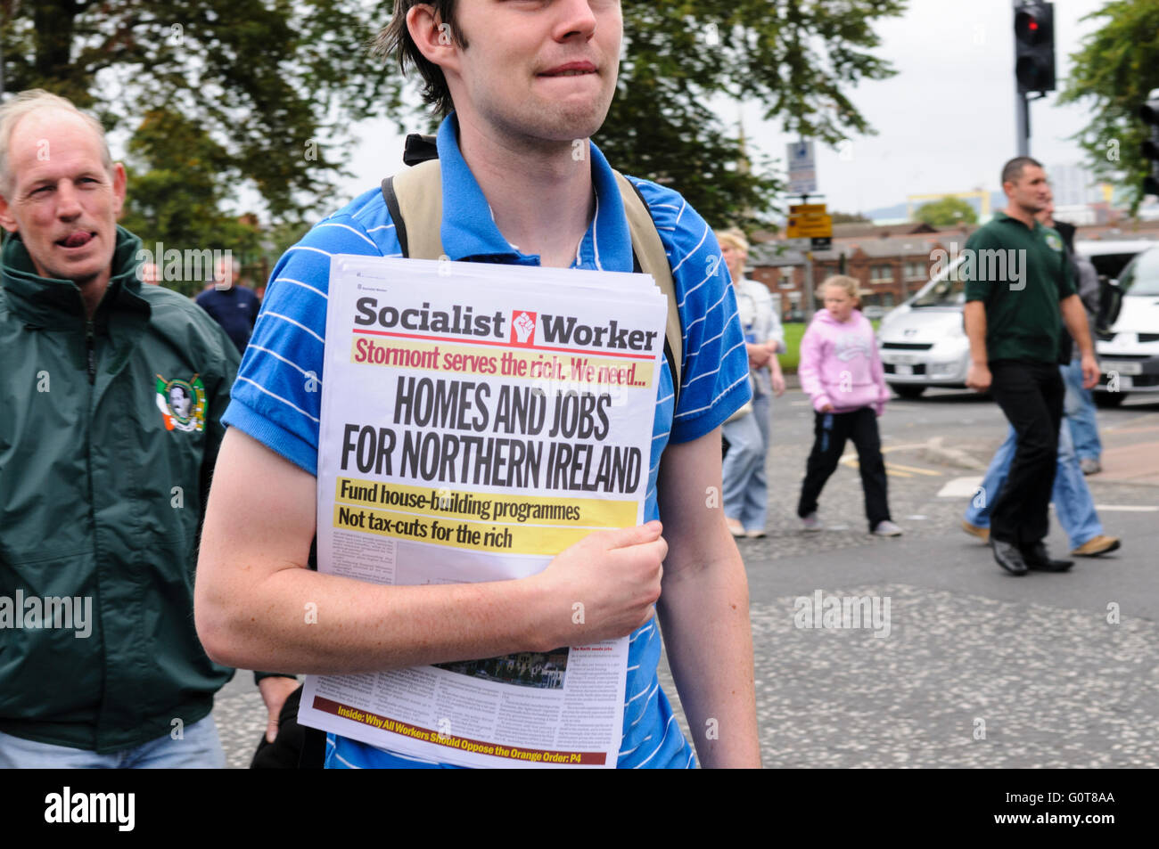 Uomo che porta copie del lavoratore socialista ad un repubblicano irlandese parade Foto Stock