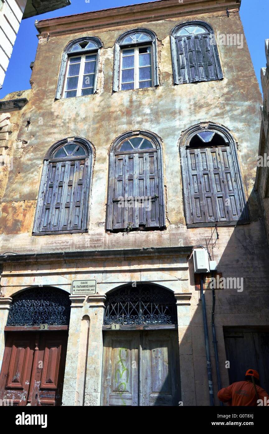 Vecchia facciata con piastrelle di rompere persiane di legno per chiudere. Foto Stock