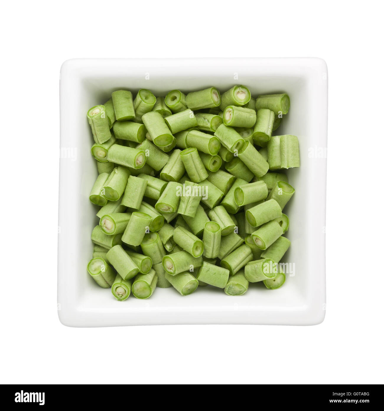 Tagliato lungo i fagioli in una terrina quadrata isolati su sfondo bianco Foto Stock