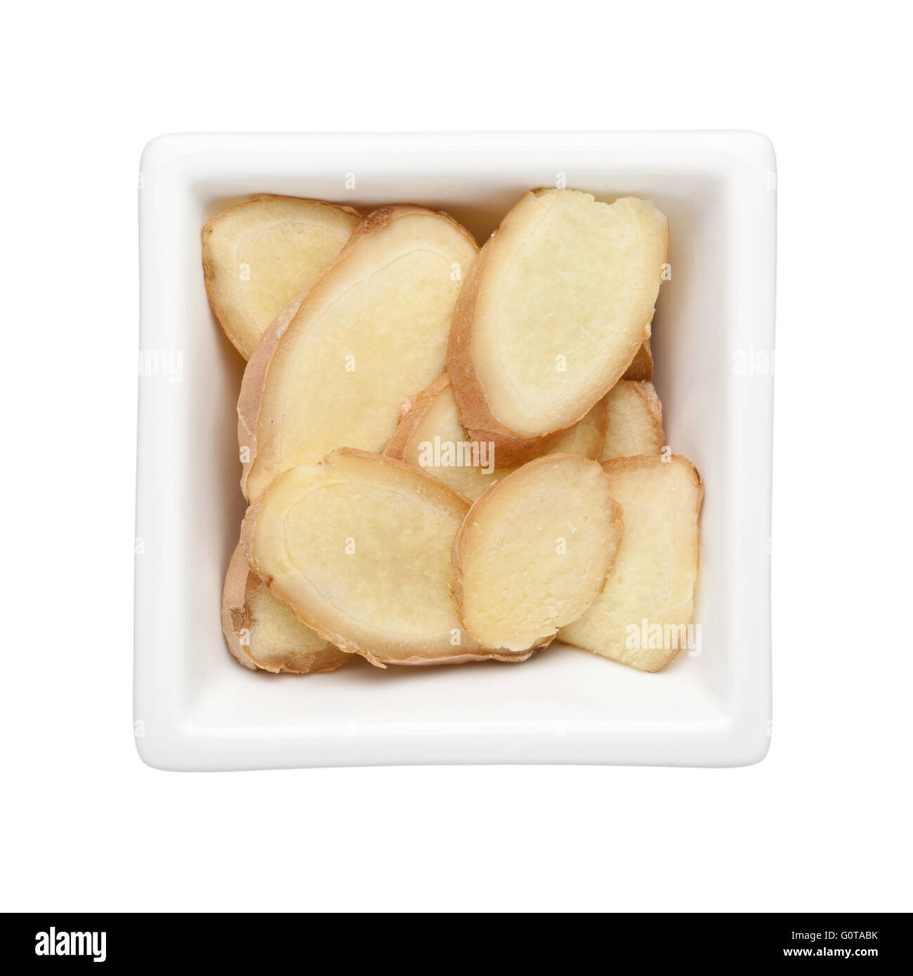 Zenzero affettato in una vaschetta quadrata isolati su sfondo bianco Foto Stock