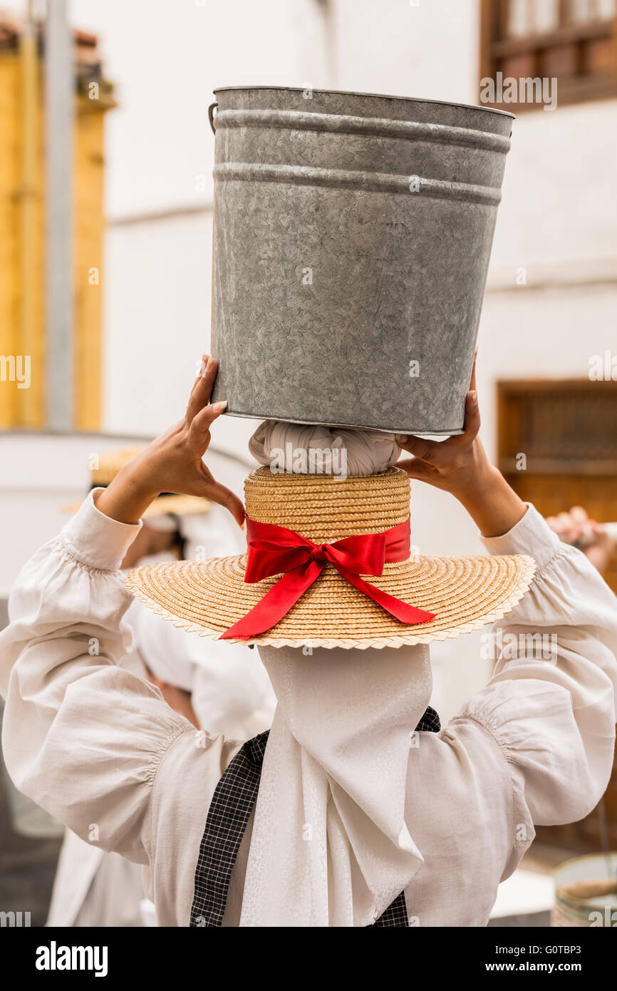 Le donne che trasportano carichi sulle loro teste in una scena come parte di un percorso guidato di percorso teatrale attraverso Adeje percorso acqua, Tenerife, Canarie Foto Stock