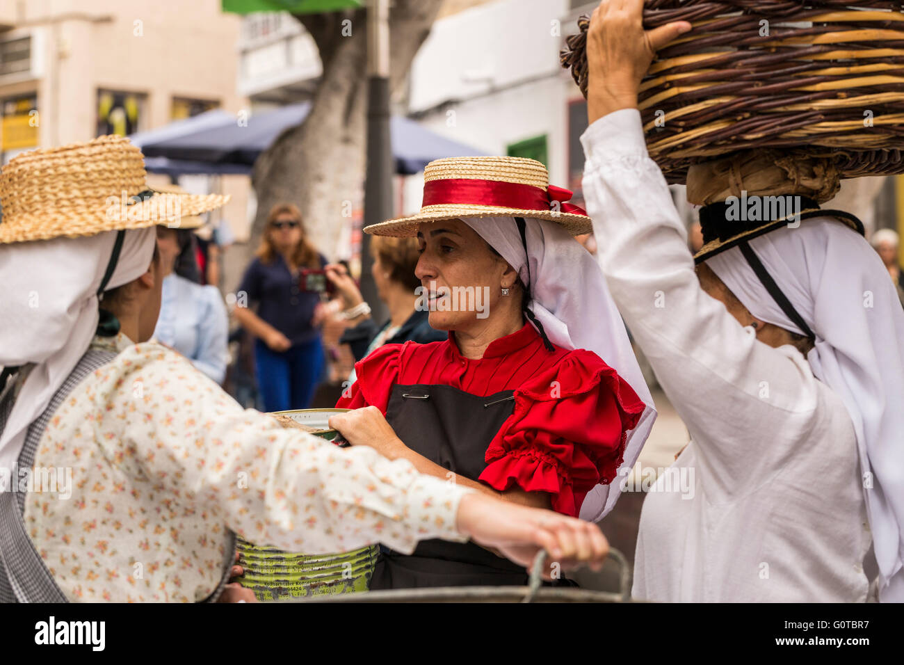 Le donne che trasportano carichi sulle loro teste in una scena come parte di un percorso guidato di percorso teatrale attraverso Adeje percorso acqua, Tenerife, Canarie Foto Stock