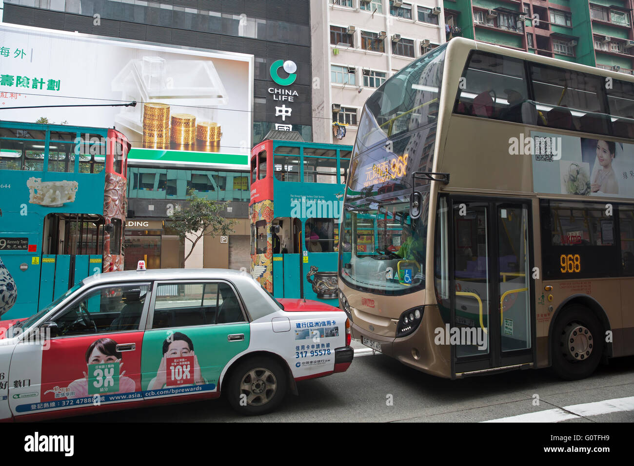 Taxi, double decker bus e un vecchio double decker tram in Hong Kong Foto Stock