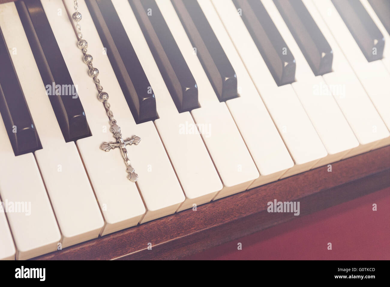 Close-up del crocifisso sulla tastiera per pianoforte Foto Stock