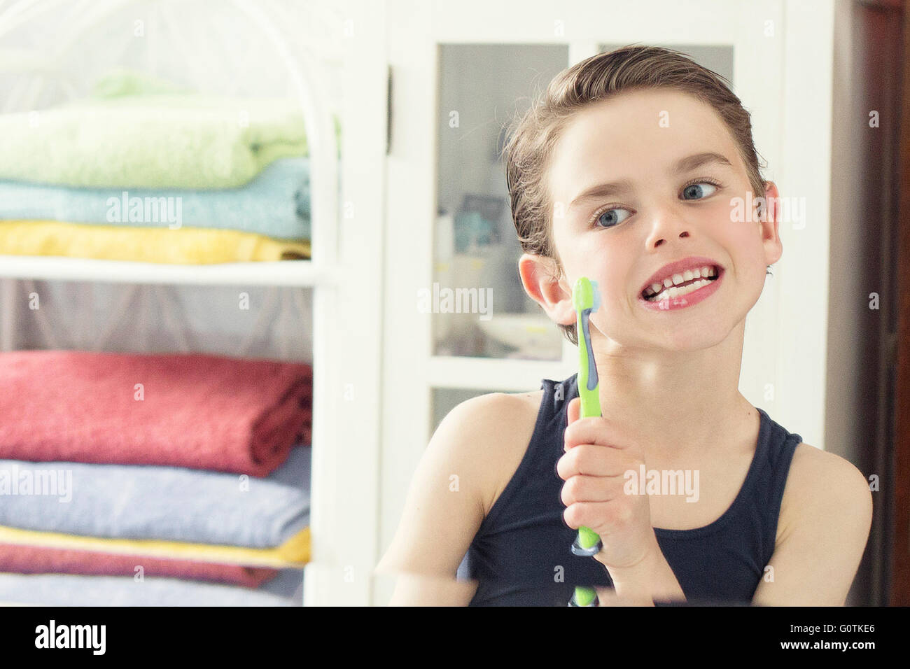 Ritratto di un ragazzo spazzolando i suoi denti nella stanza da bagno Foto Stock