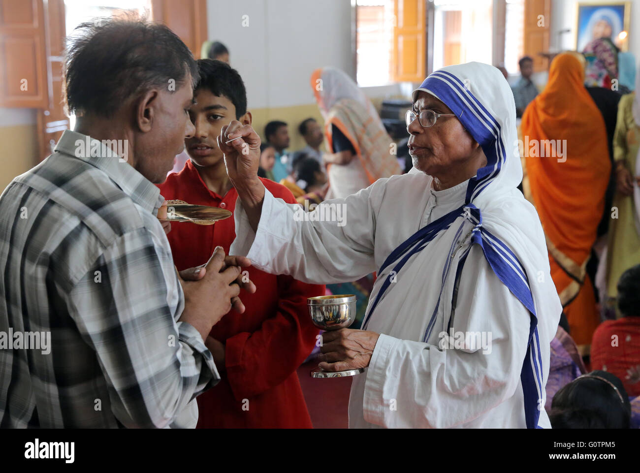 Teresa sorella (Missionari della Carità) condivide l Eucaristia durante un cattolico romano domenica a Messa in una piccola chiesa di Calcutta, in India Foto Stock