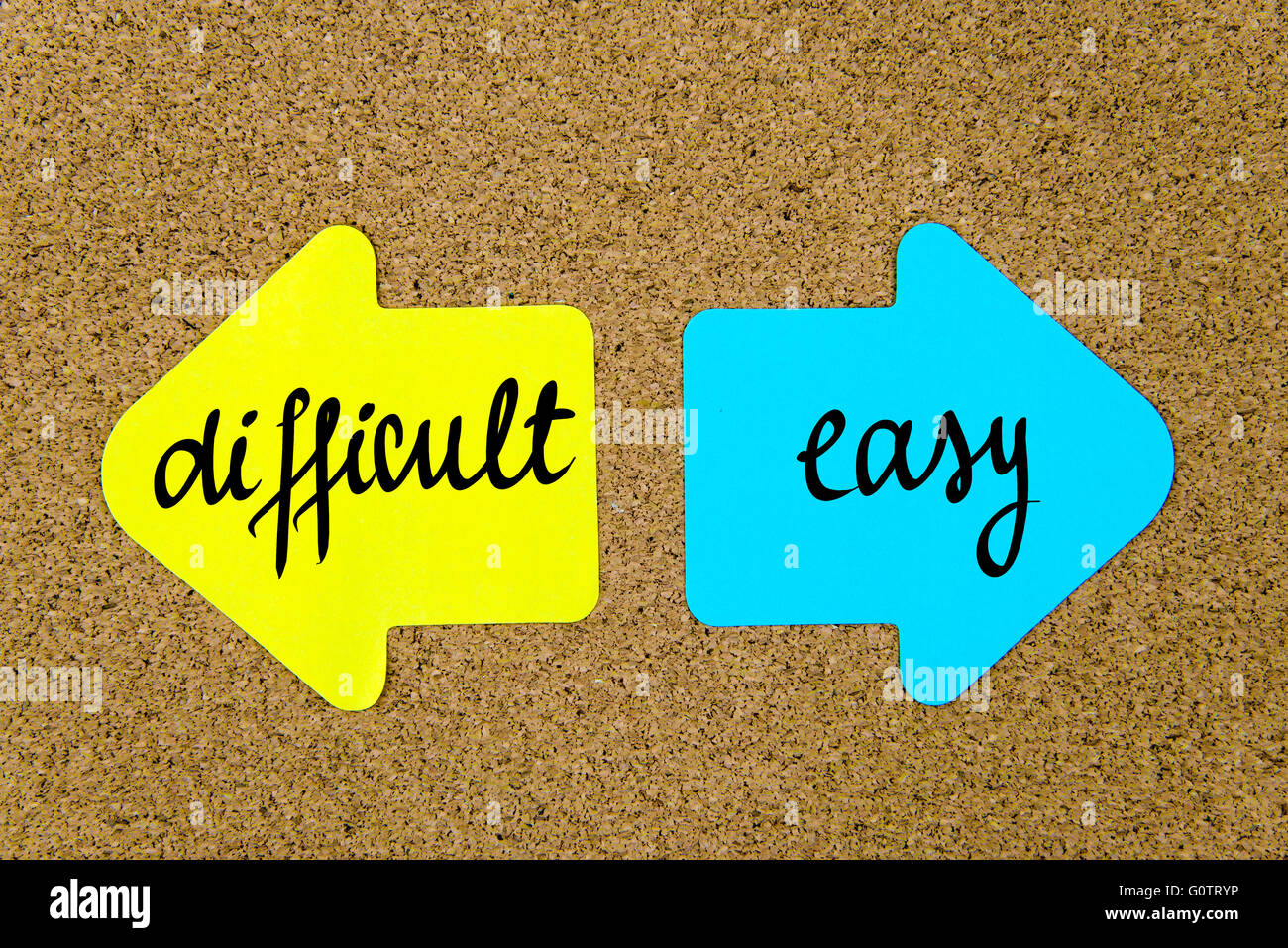 Messaggio concettuale su giallo e blu note di carta come frecce opposte imperniata sulla bacheca di sughero con thumbtacks Foto Stock