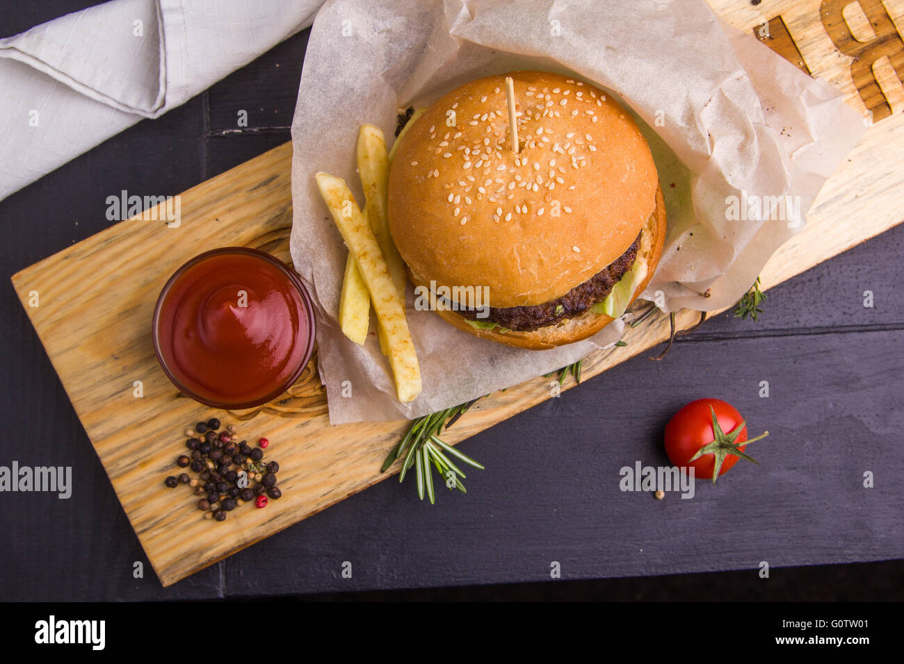Concetto: cibo sano. In casa Gourmet Burger con guarnire e ingredienti su sfondo scuro. Foto Stock