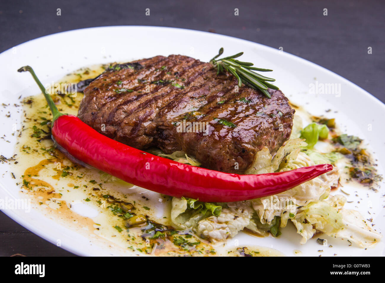 Concetto: cibo sano. In casa ai ferri Bistecca di vitello e le verdure su una piastra con ingredienti e posate intorno Foto Stock